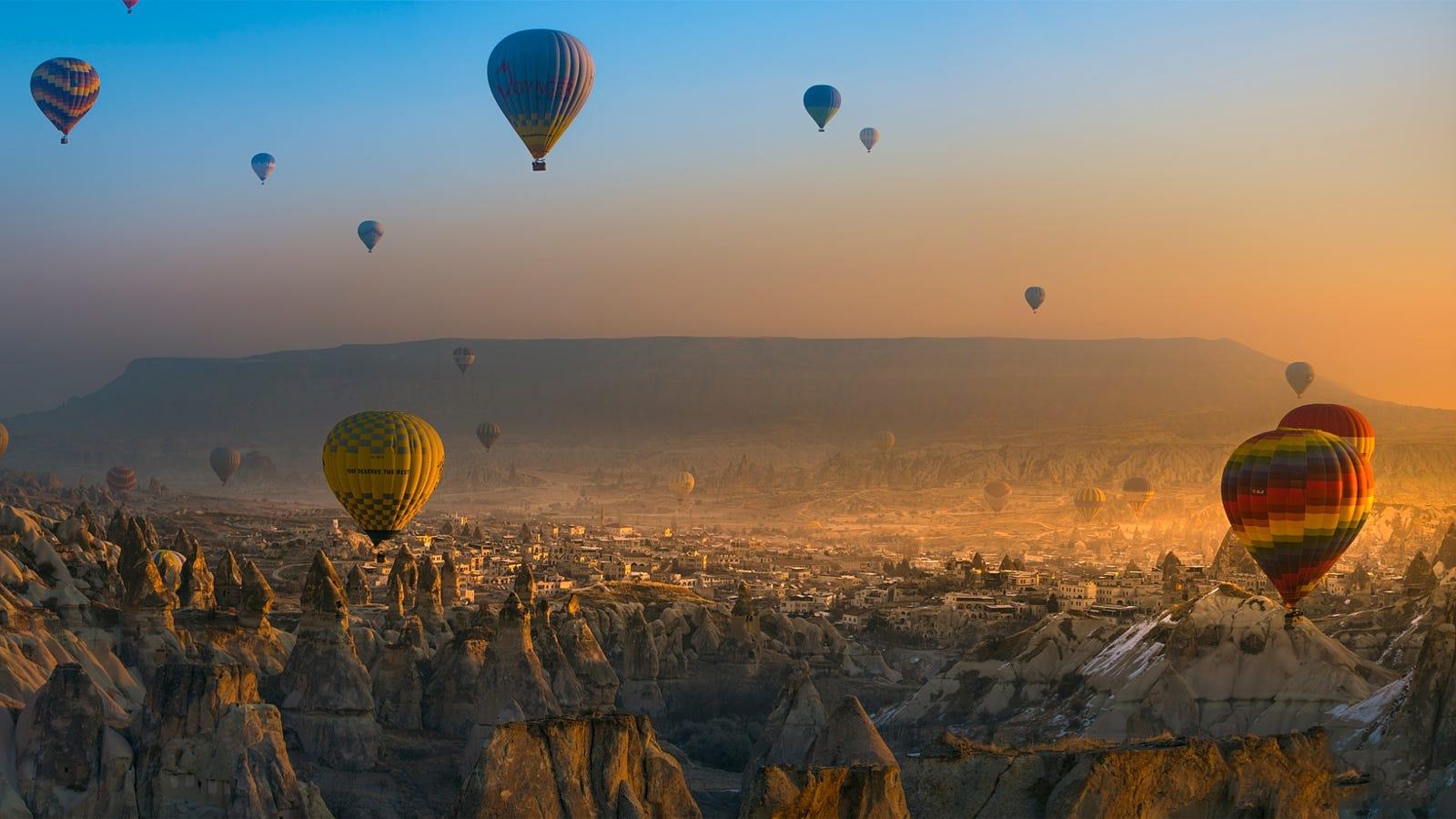 Hot-air balloons floating above Cappadocia at sunrise