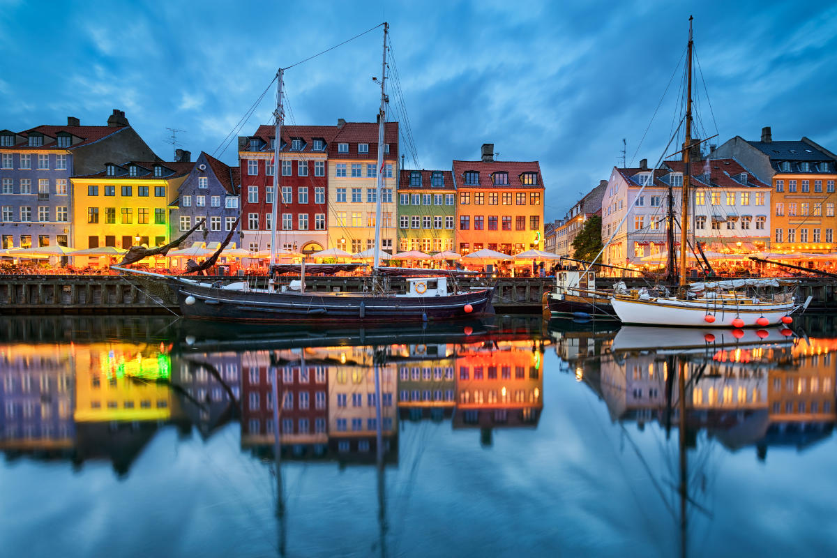 Historic boats and colourful townhouses reflected in Copenhagen’s Nyhavn harbour