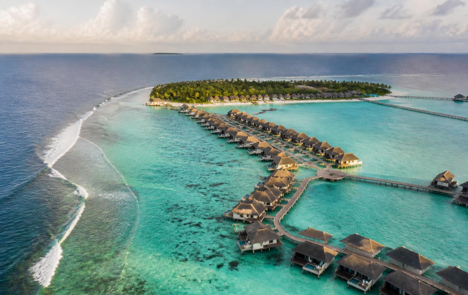 Aerial view of overwater villas in a turquoise Maldives lagoon