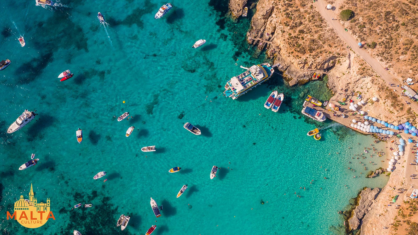 Aerial view of boats in the clear turquoise water of a Maltese lagoon